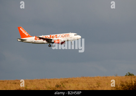 Airbus A319 d'easyJet Stansted effet Brume de chaleur apparaissant à la terre sur un champ de blé vallonnés Banque D'Images