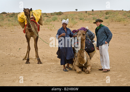Un touriste se prépare à monter sur le chameau lors d'un safari dans le désert du Thar près de Jaisalmer RAJASTHAN INDE M. Banque D'Images