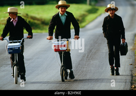 Les enfants Amish en plaine sur les vêtements traditionnels scooters sur leur chemin de retour de l'école, comté de Lancaster, Pennsylvanie, USA Banque D'Images