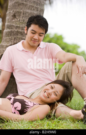 Portrait d'une jeune femme couchée avec sa tête sur les genoux d'un jeune homme Banque D'Images