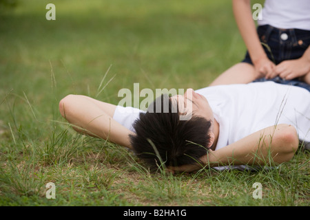 Femme assise sur un jeune homme Banque D'Images