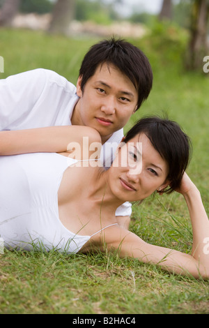Portrait d'un jeune couple couché dans l'herbe Banque D'Images