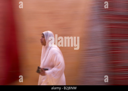 Une femme marche dans une ruelle, Marrakech, Maroc Banque D'Images