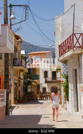 Femme marchant dans la rue étroite de la vieille ville de Malia sur l'île grecque de Crète Méditerranée UE GR Banque D'Images