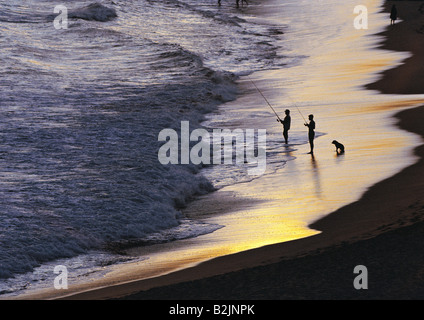 Australie. Nouvelle-Galles du Sud. Silhouette de canne hommes pêchant au large de la plage. Banque D'Images