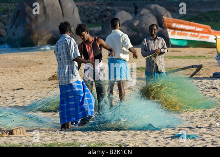 Les pêcheurs de la réparation des filets sur la plage dans le sud de l'Inde Mamallapuram Banque D'Images