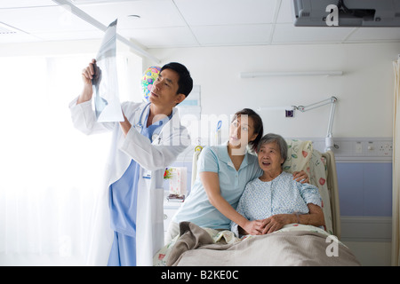 Médecin homme expliquant un X-Ray rapport à une femme et sa fille Banque D'Images