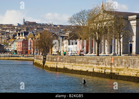 L'homme agenouillé dans un canot faire son chemin jusqu'à la rivière Lee dans le centre de la ville de Cork, Irlande Banque D'Images