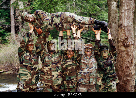 Les soldats de l'Armée US mâle tenir une femme soldat en altitude pour une photographie humoristique Banque D'Images