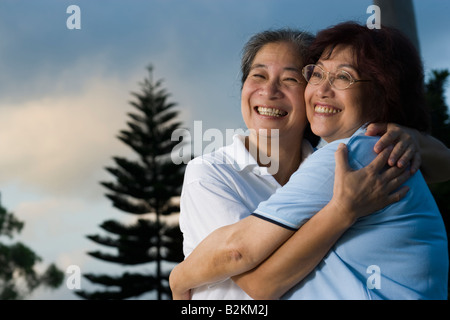 Deux hauts women hugging each other and smiling Banque D'Images