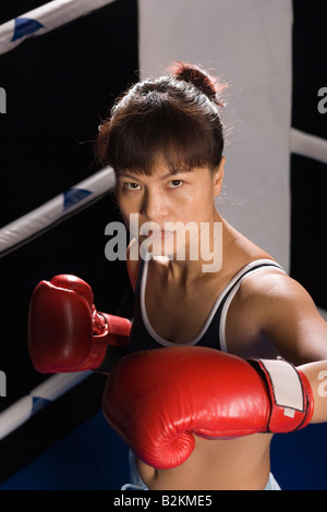 Jeune femme pratiquant la boxe dans un ring de boxe Banque D'Images