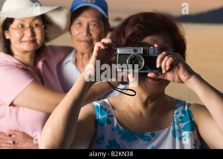 Close-up of a young woman photographing avec ses amis dans l'arrière-plan Banque D'Images