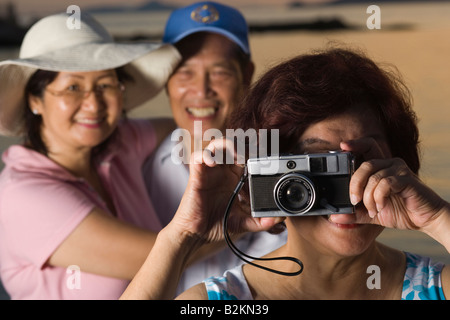 Close-up of a young woman photographing avec ses amis dans l'arrière-plan Banque D'Images