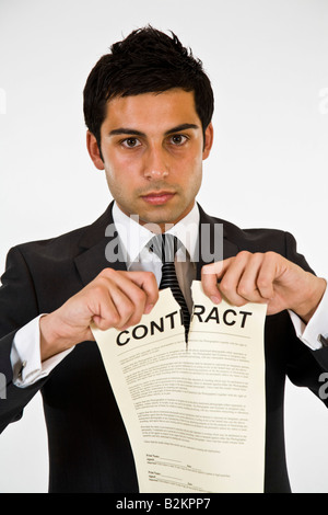 Un homme en costume de déchirer un contrat. Banque D'Images