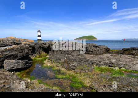 Penmon Point Lighthouse et Puffin Island au large de la côte rocheuse et perfide d'Anglesey dans le Nord du Pays de Galles Banque D'Images