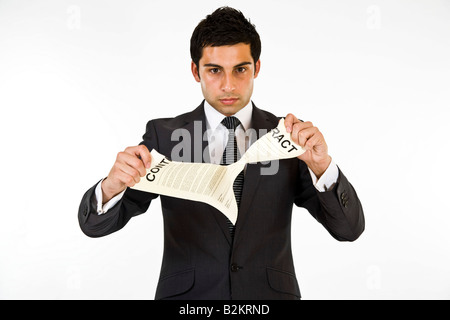 Un homme en costume de déchirer un contrat. Banque D'Images