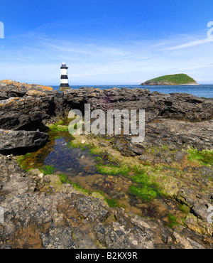 Penmon Point Lighthouse et Puffin Island au large de la côte rocheuse et perfide d'Anglesey dans le Nord du Pays de Galles Banque D'Images