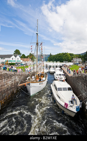 Des bateaux de plaisance entrent dans la première écluse du Loch Ness (arrière-plan) à Fort Augustus Écosse sur leur chemin en direction du sud Banque D'Images