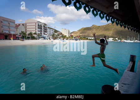 Les enfants de sauter d'un quai à Philipsburg Sint Maarten Antilles