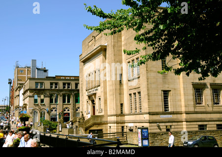 Les consommateurs et les travailleurs à l'heure du déjeuner à l'extérieur de la détente Piazza centre commercial et sur la bibliothèque comme suit à Huddersfield Banque D'Images