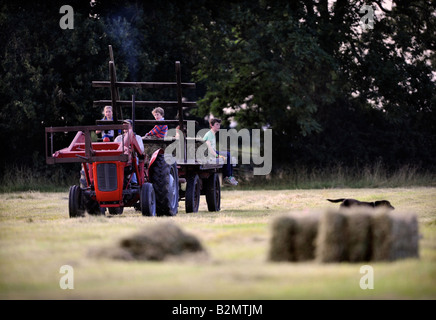 Une FAMILLE D'AGRICULTEURS LA COLLECTE DE FOIN DANS LE STYLE TRADITIONNEL DANS LE GLOUCESTERSHIRE UK Banque D'Images