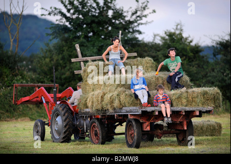 Une FAMILLE D'AGRICULTEURS LA COLLECTE DE FOIN DANS LE STYLE TRADITIONNEL DANS LE GLOUCESTERSHIRE UK Banque D'Images