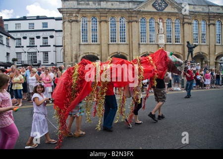 Carnaval à Monmouth Dragon en face de Shire Hall avec Charles Rolls statue et Henry V et petite fille. Banque D'Images