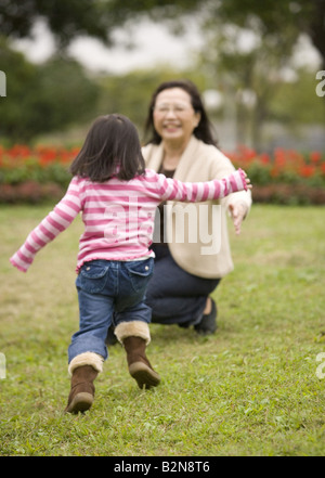 Hauts femme jouant avec sa petite-fille dans un parc Banque D'Images