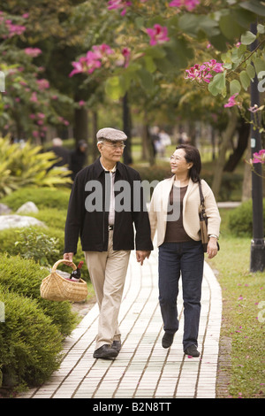 Senior couple walking in a park and smiling Banque D'Images