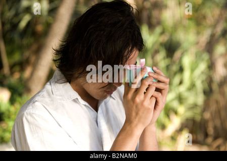Close-up of a young man holding a gift, Phuket, Thailand Banque D'Images