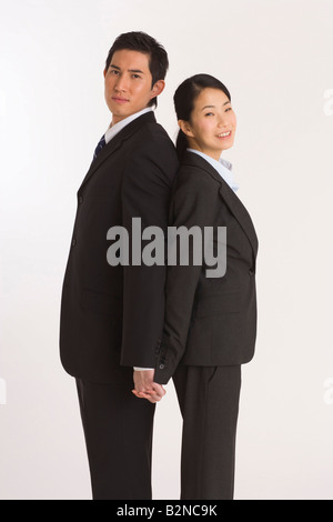 Woman standing back to back avec leurs mains Banque D'Images