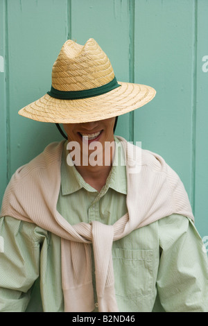 Close-up of a Mid adult man portant un chapeau de paille et souriant Banque D'Images
