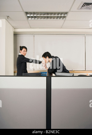 Portrait of young woman kissing man's hand dans un bureau Banque D'Images