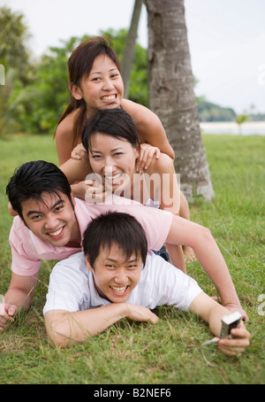 Portrait de deux jeunes couples de prendre une photo d'eux-mêmes avec un appareil photo numérique Banque D'Images