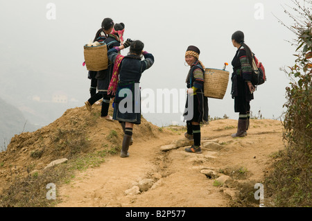 Cinq femmes des tribus Hmong noir sur un Misty Mountain top à Sapa, Vietnam Banque D'Images