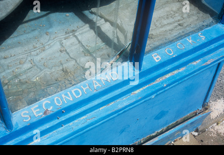 Une fois la fenêtre boutique élégant avec cadre en bois bleu avec des lettres à l'abandon maintenant bloqué sur châssis, mais l'épluchage indiquant Secondhand Books Banque D'Images