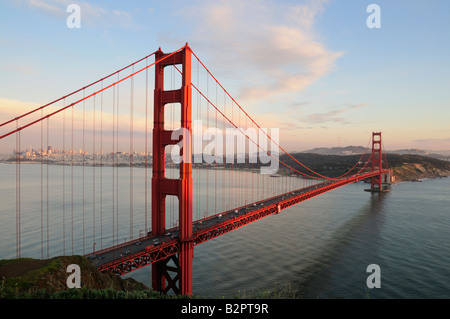 Golden Gate Bridge éclairées par le soleil couchant dans le contexte de l'horizon de San Francisco et beau ciel nuageux Banque D'Images