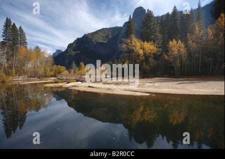 Les couleurs d'automne et falaises de granit gris de Yosémite reflète dans l'eau lisse de la Merced Banque D'Images