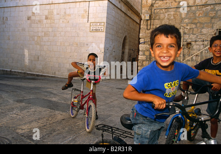 Garçons jouant sur des bicyclettes dans la vieille ville de Jérusalem, Israël, Moyen-Orient, portrait Banque D'Images