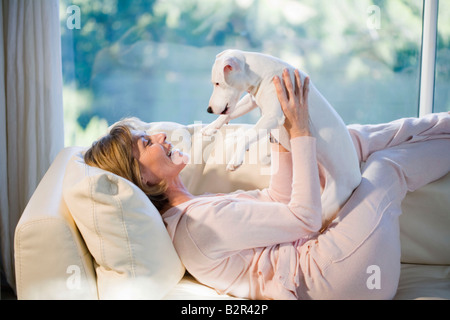 Woman Relaxing, Playing with Dog Banque D'Images
