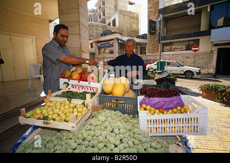 Titulaire de décrochage de fruits frais de vente au client sur street market stall, Lebenon, Moyen-Orient Banque D'Images