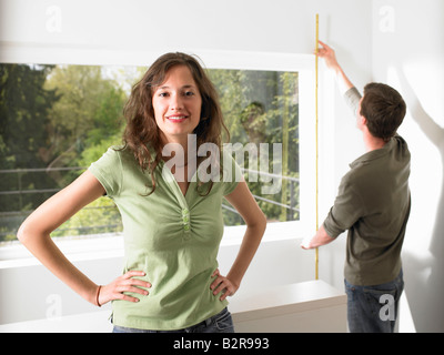 Couple qui mesure de leur accueil Banque D'Images