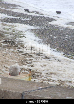 Vieil homme assis sur la plage de Muro, au nord du Pays de Galles Banque D'Images