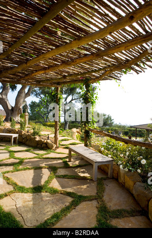 Vieux banc en bois, sous un grand auvent de patio en pierre Banque D'Images