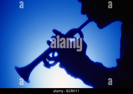 Silhouette d'un homme jouant de la trompette avec un fond bleu Banque D'Images