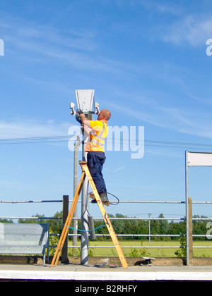 Un ingénieur des chemins de la réparation de l'équipement à un calendrier electroic la plate-forme, UK Banque D'Images