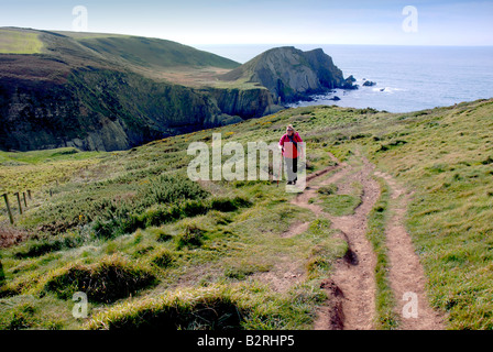 Femelle solitaire Walker sur le chemin côtier du sud-ouest Hartland Devon, Angleterre Royaume-uni Banque D'Images