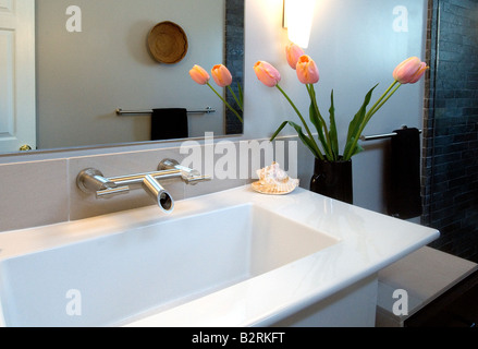 Salle de bains moderne avec lavabo blanc tulipes roses Banque D'Images