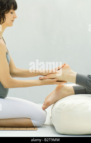 Woman performing massage des pieds, side view Banque D'Images