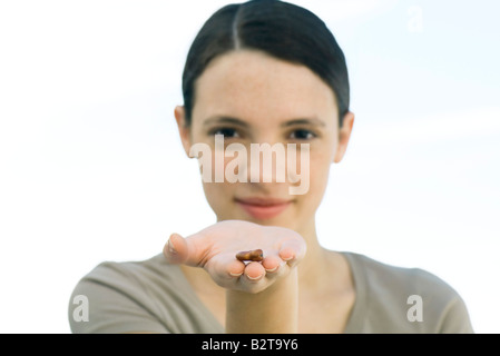 Young woman holding out haricots secs dans la paume de la main Banque D'Images